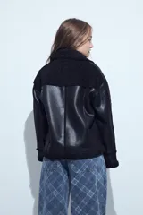 Gamulán de cuero sintético en color marrón oscuro con interior de corderito al tono. Presenta cierre diagonal, cuello amplio con solapas y puños con detalle de corderito.