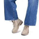 Borcegos de estilo urbano en color beige, confeccionados en material símil cuero. Presentan cordones al tono, ojales metálicos, cierre lateral interno y detalle de piel sintética en el borde superior. Cuentan con suela de goma con relieve antideslizante y taco medio con acabado símil madera.