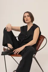 Chaleco marrón con rayas verticales rosas, de corte sastrero y sin mangas.