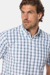 Camisa sport de manga corta a cuadros en tonos suaves de verde y azul sobre fondo blanco, con cuello camisero y cierre frontal de botones.