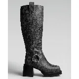 Bota alta de cuero vacuno color negro con efecto craquelado, taco ancho de madera y plataforma delantera. Presenta punta cuadrada, costuras decorativas en la caña y una tira con hebilla metálica y argolla alrededor del tobillo.