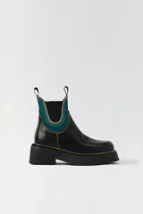 Botas Chelsea negras de cuero con elástico lateral azul y pespuntes amarillos.