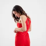 Vestido corto negro con escote halter, tiras finas cruzadas en la espalda y aberturas laterales en la cintura.