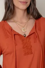 Remera negra de algodón de manga larga con aplique de encaje en el escote.