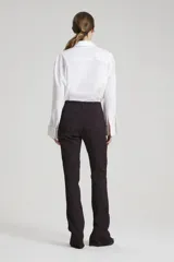 Pantalón de tiro alto con estampado abstracto en tonos borgoña y negro, con cierres invisibles en la parte inferior de la bota en los laterales y recortes verticales.