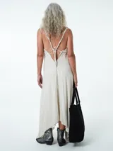 Vestido largo confeccionado en mezcla de lino y viscosa, con escote en V profundo, tirantes finos y espalda baja. Posee un diseño fluido con bajo asimétrico de caída en picos.