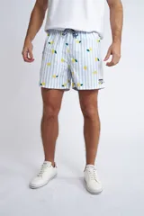 Short de baño con cintura elástica y cordón ajustable, confeccionado en tela ligera de secado rápido. Presenta un estampado botánico integral en tonos amarillos, blancos y azules, con dos bolsillos delanteros y uno posterior.