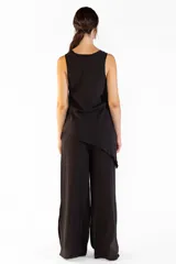 Pantalón ancho negro con bolsillos laterales, pretina elástica y cortes en los laterales que aportan movimiento. Confeccionado en mezcla de tencel y nylon.
