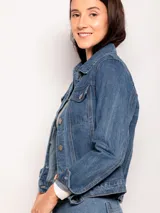 Campera de jean clásica con lavado vintage, corte corto, bolsillos frontales y cierre mediante botones metálicos.