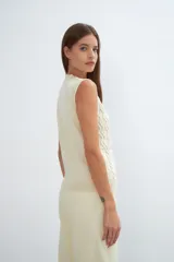 Chaleco de lana color crudo, tejido con escote en V y diseño con diferentes puntos combinados en el frente.