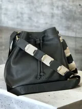 Bolso tipo marinero de cuero genuino negro, con cierre de cordón ajustable, correa corta de cuero y correa larga ajustable de tela.