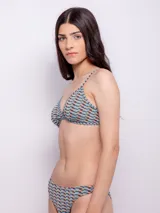 Conjunto de bikini estampado con motivos geométricos en tonos celeste y naranja. El corpiño es de corte triangular con breteles finos regulables y copas desmontables. La bombacha es de corte clásico.