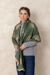 Pashmina reversible de textura suave y caída fluida, con diseño estampado de hojas tipo ginkgo biloba en tonos verdes y beige. Presenta flecos cortos en los extremos y muestra el negativo del diseño en el reverso.