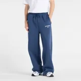 Pantalón de jogging New Balance color azul, de corte holgado y diseño recto. Cuenta con cintura elástica con cordón ajustable, bolsillos laterales y una línea vertical blanca a lo largo de la pierna. Presenta el logo de la marca bordado en el muslo.