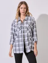Sobrecamisa cuadrillé blanca y negra con cuello con solapa, abertura central con botones, bolsillos aplicados y mangas largas regulables con presilla y botón. Terminación de ruedo desflecado.