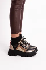 Borcegos de cuero vacuno color negro, beige y marrón claro, con cordones negros, suela de goma track color negro y plataforma de 5 cm.