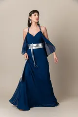 Vestido largo de fiesta color azul, confeccionado en gasa con corsé drapeado y breteles bordados. Presenta una capa de gasa que nace de los breteles. Incluye un cinturón plateado.