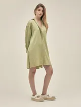 Camisa larga color crema confeccionada en lino-tencel con botones de conchas naturales y bolsillos laterales.