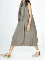 Vestido largo color visón de lino con cuello volcado y bolsillos laterales.