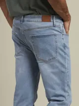 Pantalón de jean azul claro, corte recto, con bolsillos delanteros y traseros.
