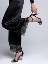 Pantalón negro de razo con terminación en encaje.