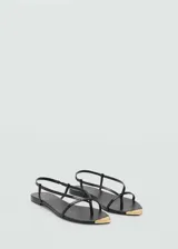 Sandalias planas de cuero negro con diseño de tiras finas, cierre elástico en el talón y detalle metálico dorado en la puntera.