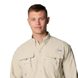 Camisa de manga larga Columbia modelo Bahama II, color beige, diseñada para actividades al aire libre. Presenta cuello abotonado, dos bolsillos frontales con solapa, ventilación trasera forrada en malla y pestañas para sujetar las mangas enrolladas.