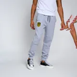 Pantalón de jogging negro con puños ajustados en los tobillos y cordón en la cintura. Presenta un escudo bordado en amarillo y negro en la pierna izquierda.