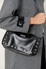 Cartera de hombro color bordó, confeccionada en cuero con acabado brillante. Presenta detalles de remaches metálicos plateados en los laterales y la base, y una correa ajustable con hebilla. Incluye una placa metálica con el logo de la marca en la parte frontal.