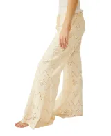 Pantalón de broderie color blanco, de pierna ancha, con cordón ajustable en la cintura y diseño calado con patrones geométricos.
