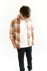 Camisa leñadora a cuadros color mostaza, blanco y gris, de manga larga y corte clásico.