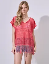 Kaftan blanco calado con cuello a la base, escote en V y lazo de ajuste. Terminación de ruedo con flecos.