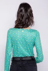 Top corto de manga larga con estampado geométrico en tonos verde agua y blanco.