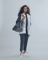 Chaleco largo negro estilo puffer con capucha y cierre frontal.