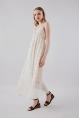 Vestido midi de tirantes finos en color blanco, con escote en V profundo y diseño con textura floral bordada y sutiles lentejuelas brillantes.