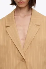 Chaqueta color tostado con diseño de rayas diplomáticas verticales en tono claro, solapas de muesca, cierre frontal de dos botones y bolsillos laterales con solapa.