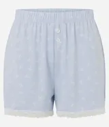 Short de pijama celeste de peach touch con estampa de moñitas blancas, cintura elastizada con bragueta frontal de botones y detalle de encaje blanco en los bajos.