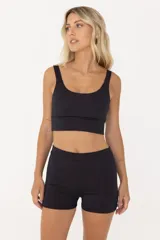 Top deportivo negro con tirantes anchos y largo intermedio. Cuenta con compresión media y espacio para agregar tazas.
