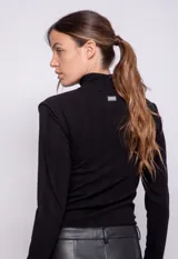 Polera de cuello alto y manga larga, confeccionada en tejido de punto acanalado con ajuste al cuerpo.