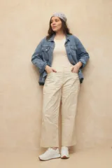 Pantalón color beige, de corte recto, con bolsillos laterales y recortes tipo cargo.