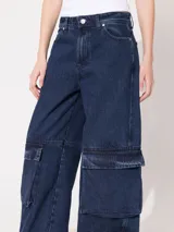 Pantalón de jean azul oscuro, corte wide leg con tiro medio y bolsillos cargo.