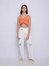 Top blanco de tela texturada, sin mangas y con cuello redondo. Cuenta con cuatro botones y terminación en curva en la parte delantera.