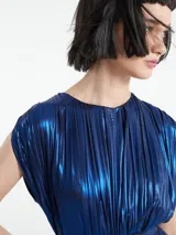 Mono largo sin mangas de corte holgado, confeccionado en tejido plisado con acabado metalizado. Presenta cuello redondo con detalle de abertura y cierre de botón en la parte posterior.