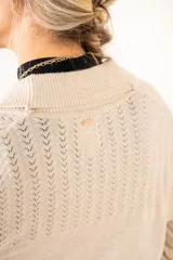 Cardigan color salmón de algodón y elastano, con solapa y lazo ajustable en la cintura.