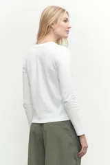 Remera de manga larga color blanco, con cuello redondo y calce al cuerpo.