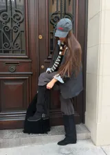 Bota alta de gamuza negra con caña alta, flecos laterales, tiras con hebillas metálicas en el tobillo y taco cuadrado.