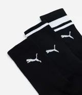 Kit de tres pares de medias deportivas Puma de caña larga, confeccionadas en algodón. Incluye un par blanco con rayas y logo azules, un par negro con rayas y logo blancos, y un par liso de color azul.
