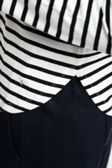 Remera de manga larga con diseño de rayas horizontales en blanco y negro, cuello redondo y corte ajustado al cuerpo.