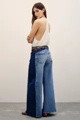 Jean de corte wide leg con diseño bicolor que combina tonos de denim azul claro al frente y azul oscuro en los laterales.