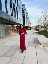 Vestido largo color borgoña, de corte ajustado, con cuello alto y mangas largas.